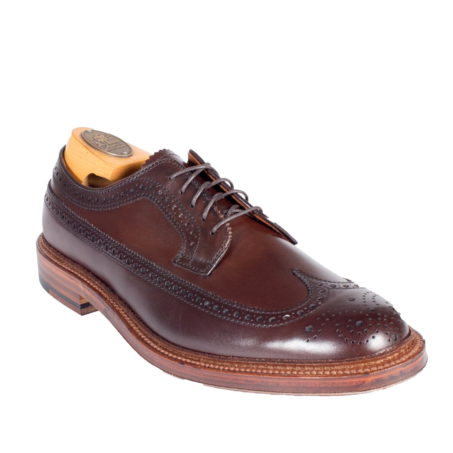The Alden Madison 976 - Long Wing Blucher features premium brown calfskin, intricate stitching, decorative perforations, a detailed double Waterlock sole with a stacked heel, and a wooden shoe tree.