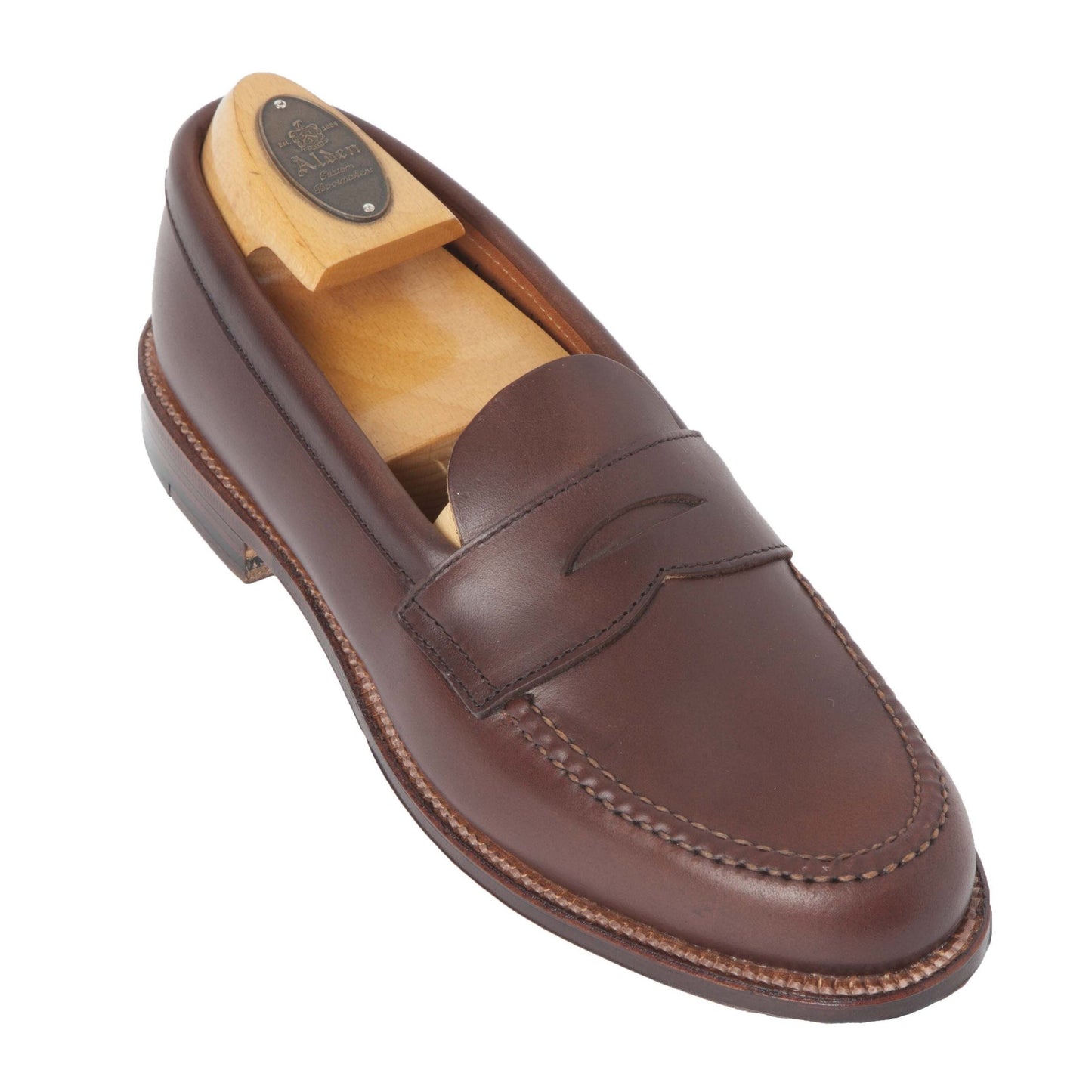A single brown Chromexcel loafer by Alden Madison, crafted on the Van Last, showcases a classic design with moccasin-style stitching, a strap cutout, and a smooth leather sole. Includes wooden shoe tree. Product: 17831F - Unlined Leisure Hand Sewn.