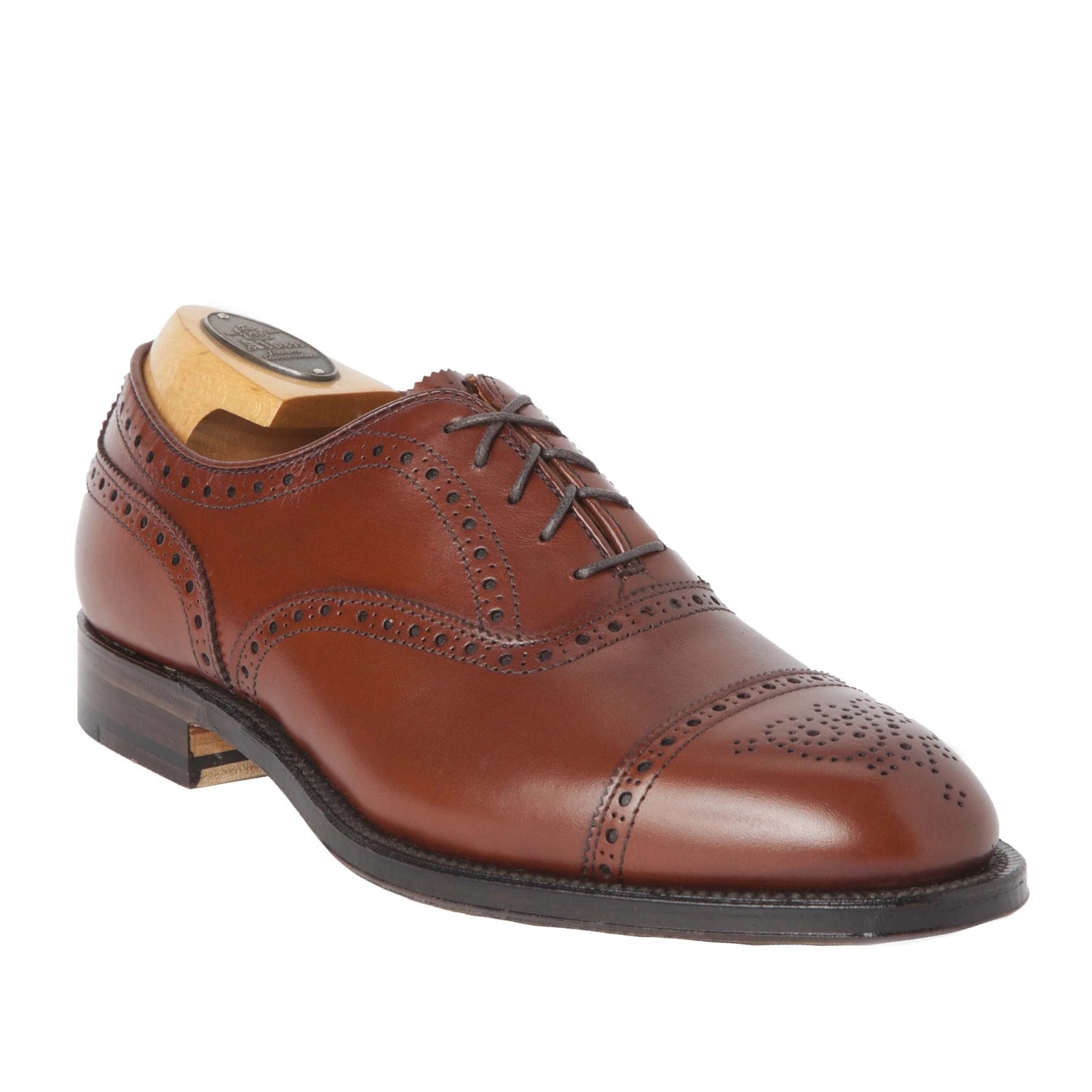 The Alden Madison 911 - Burnished Tan Medallion Cap Toe Bal features a classic design crafted on the Hampton Last with brogue detailing, closed lacing, and a leather sole. Its polished finish highlights its elegance in Burnished Tan Calfskin.