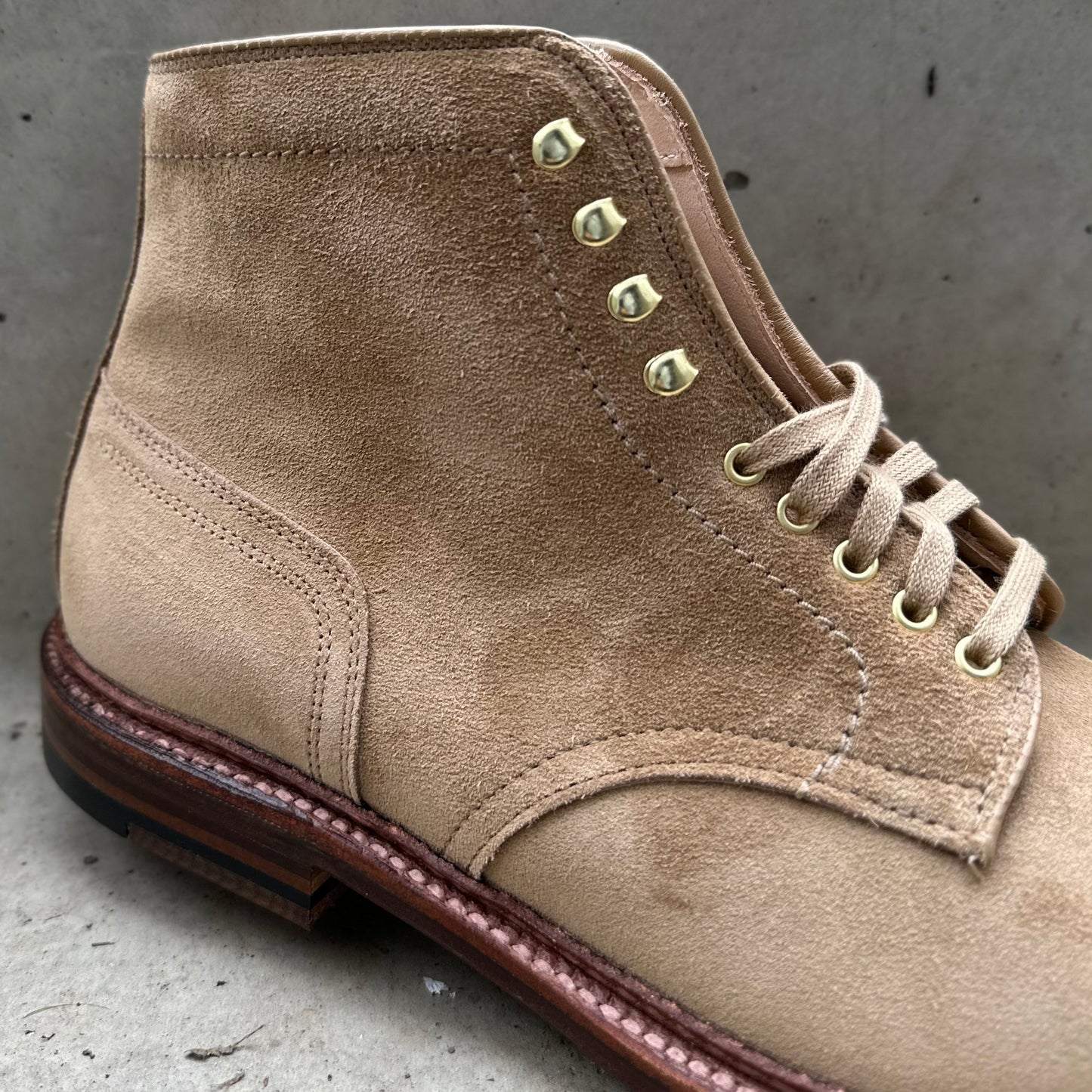 The D2685H - 2/2 Cap Toe Boot in Tan Suede by Alden Madison features a Barrie Last design with a brown leather sole, visible stitching, and tan laces threaded through metal eyelets, stylishly displayed on concrete.