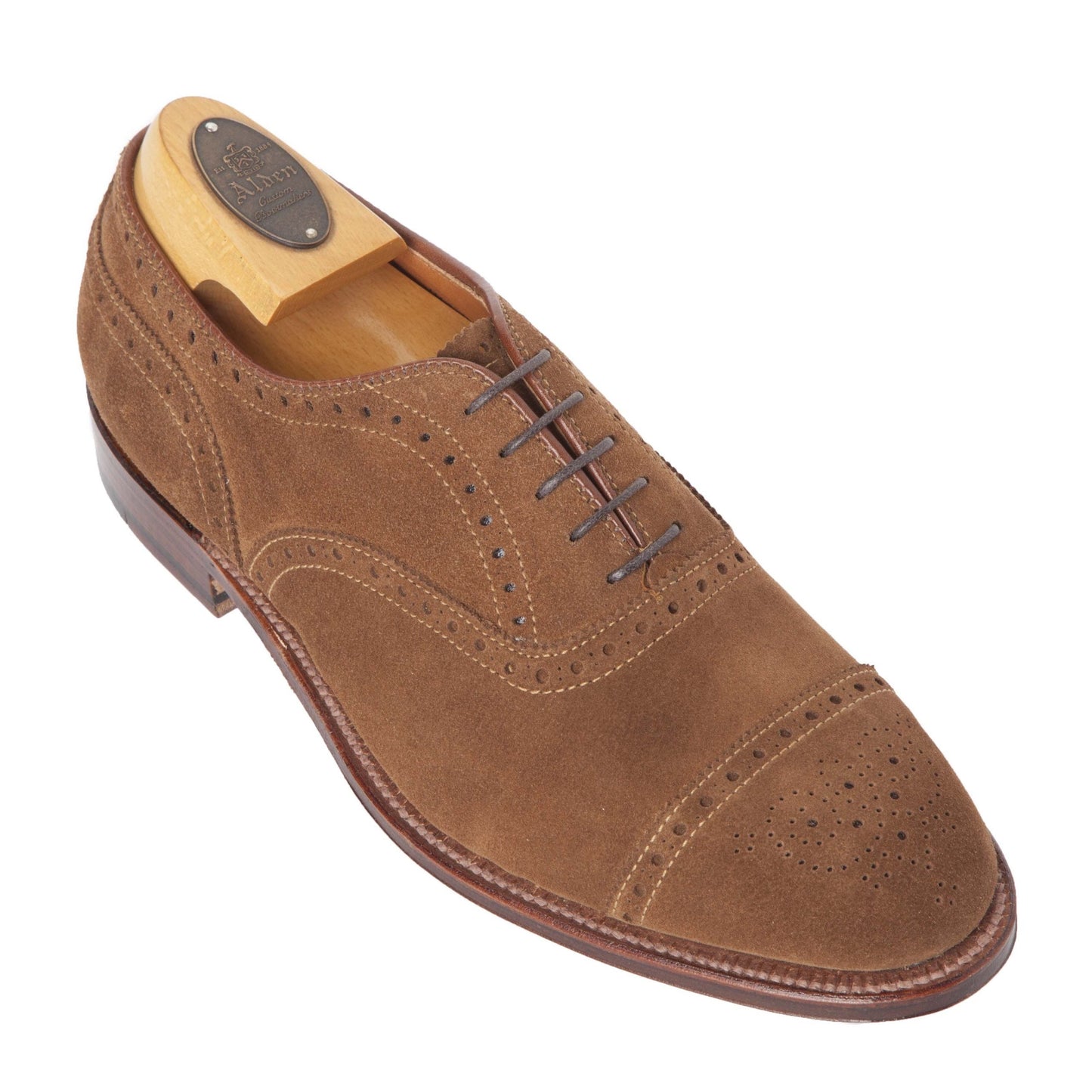 The Alden Madison 51670F - Medallion Cap Toe Bal in Snuff Suede is a brown suede oxford with decorative perforations, brown laces, a Flex leather sole, and comes with a wooden shoe tree.