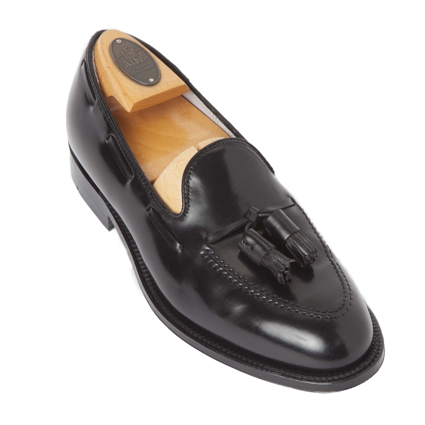 The Alden Madison 664 Tassel Loafer in Black Shell Cordovan features a leather outsole and includes a wooden shoe tree.