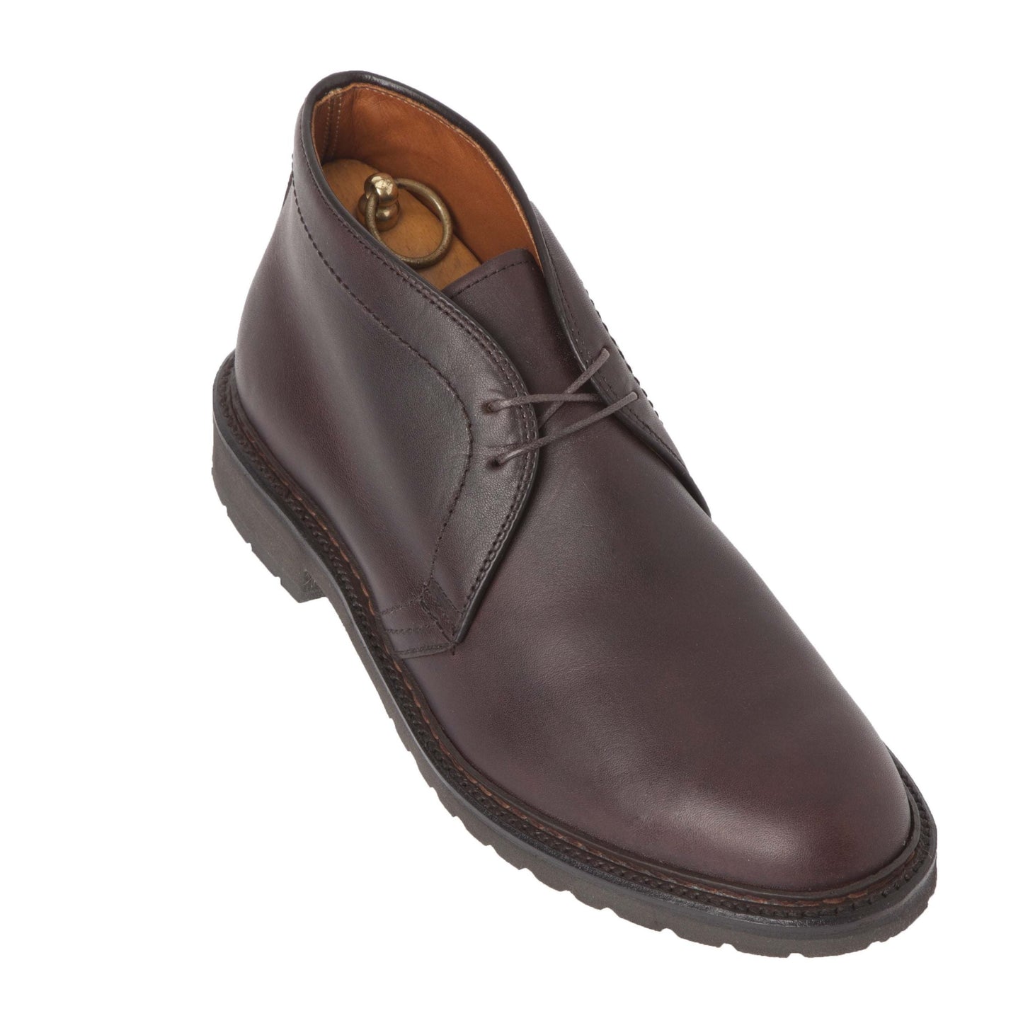 The Alden Madison 1272S Chukka Boot, made from kudu leather in dark brown, showcases a lace-up design and thick Lug Rubber Sole. Viewed from above, a partially visible shoe tree provides structure within the boot.