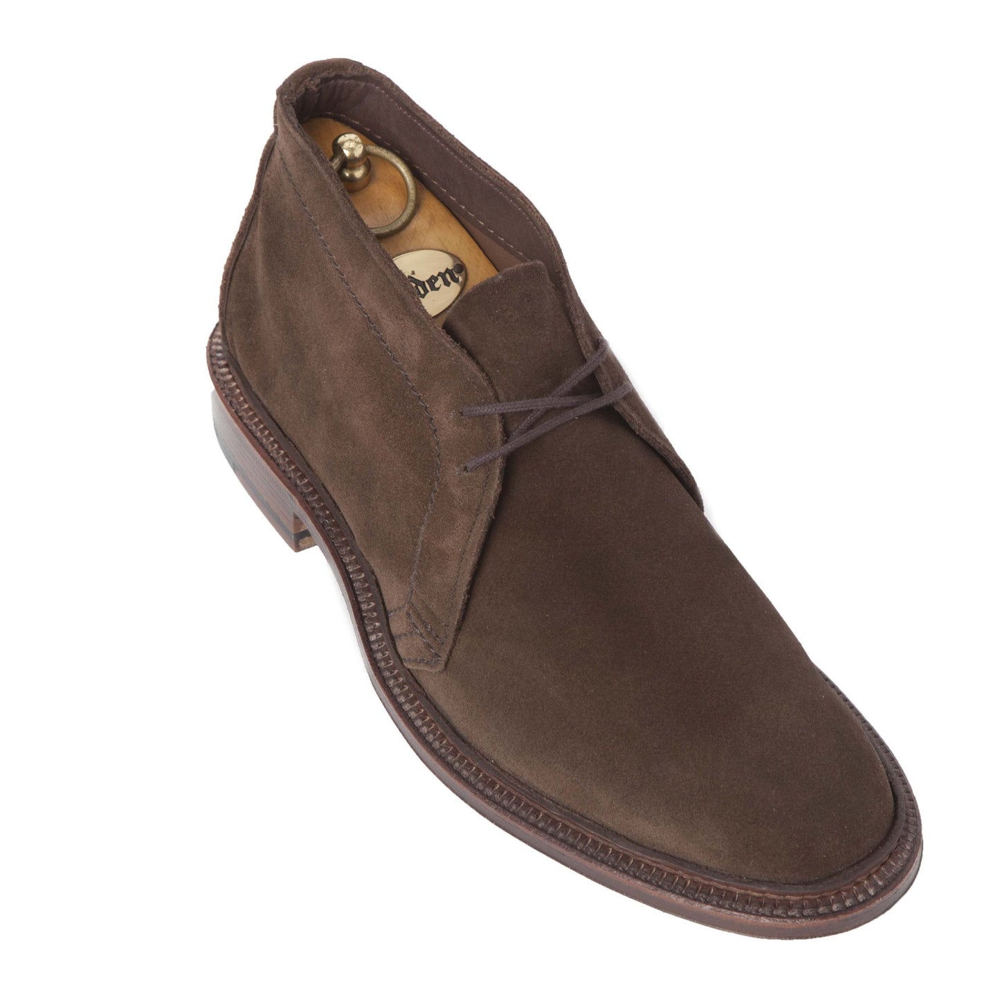 The Alden Madison 1492 - Unlined Chukka in Brown Suede features a polished leather sole, slightly raised heel, brown laces, and includes a wooden shoe tree inside. Crafted on the Leydon Last, it combines classic style with refined comfort.