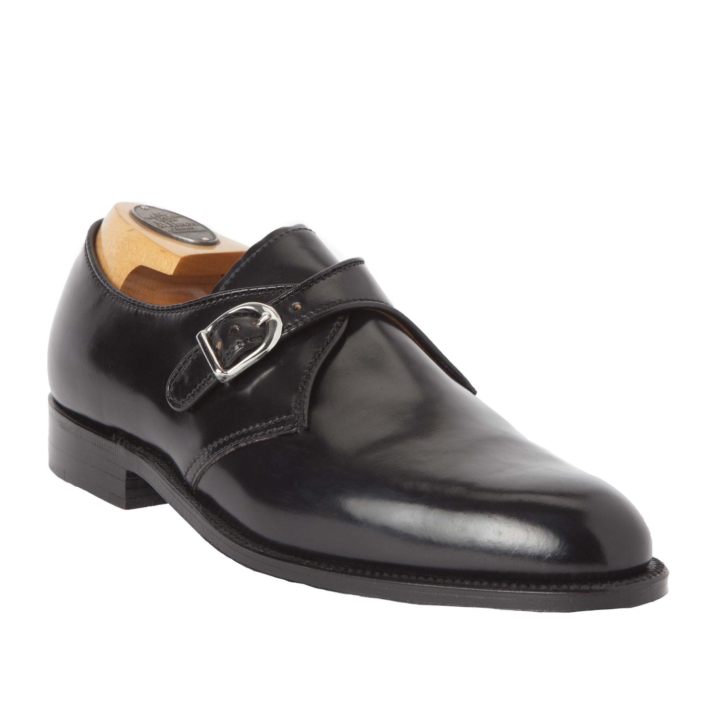 The Alden Madison 1655 - Monk Strap Black in Shell Cordovan shoe has a nickel buckle, low heel, and slightly pointed toe. It sits on a light wooden shoe form showcasing its elegant craftsmanship.