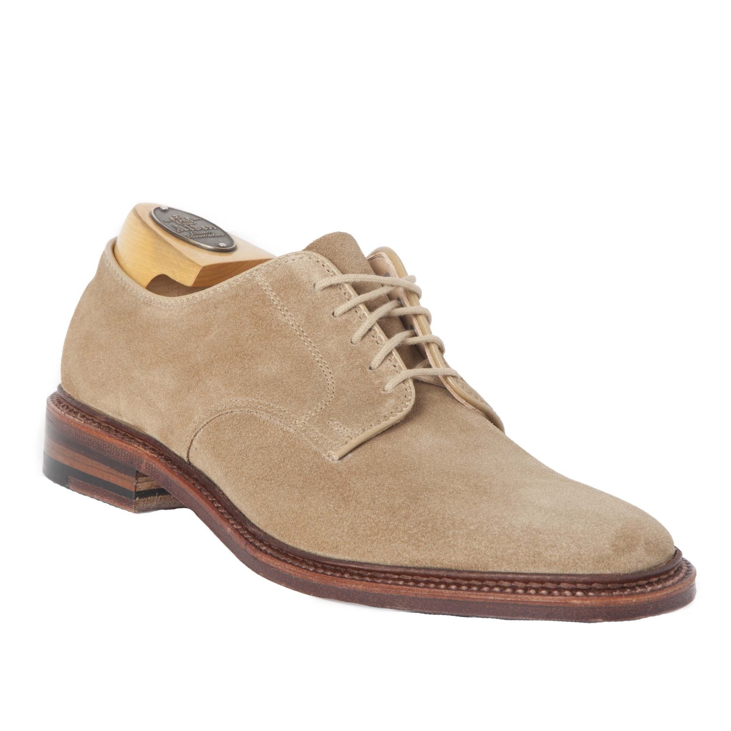 The Alden Madison 29332F Unlined Plain Toe Blucher is a tan suede dress shoe crafted on the Barrie Last. It includes laces, a wooden shoe tree, a Flex Leather Sole with a brown finish, and a dark heel for added elegance.