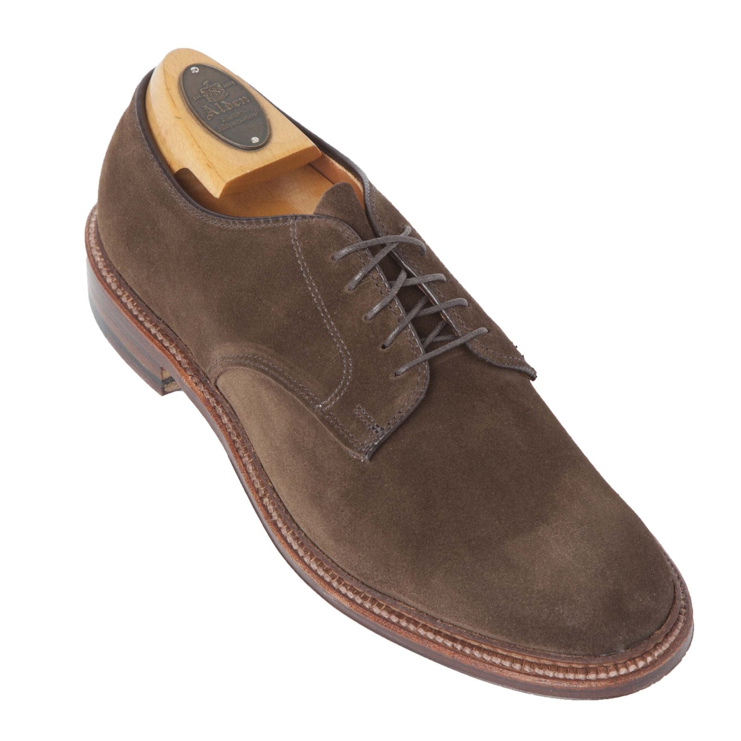 The Alden Madison 29335F - Unlined Dover in Brown Suede is a brown suede lace-up shoe on a Barrie Last, featuring a smooth, rounded toe with visible stitching along the medium brown storm welt sole and includes a wooden shoe tree.