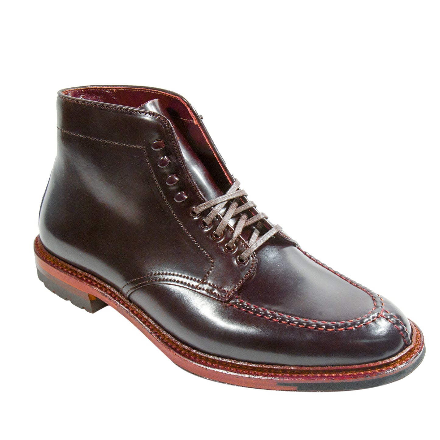 The Alden Madison 40218HC - NST Tanker Boot in Color 8 Shell Cordovan is a sophisticated dark brown leather boot crafted on the Barrie Last, with red welt stitching, a polished finish, laces, sturdy Commando Sole, and detailed toe cap stitching.