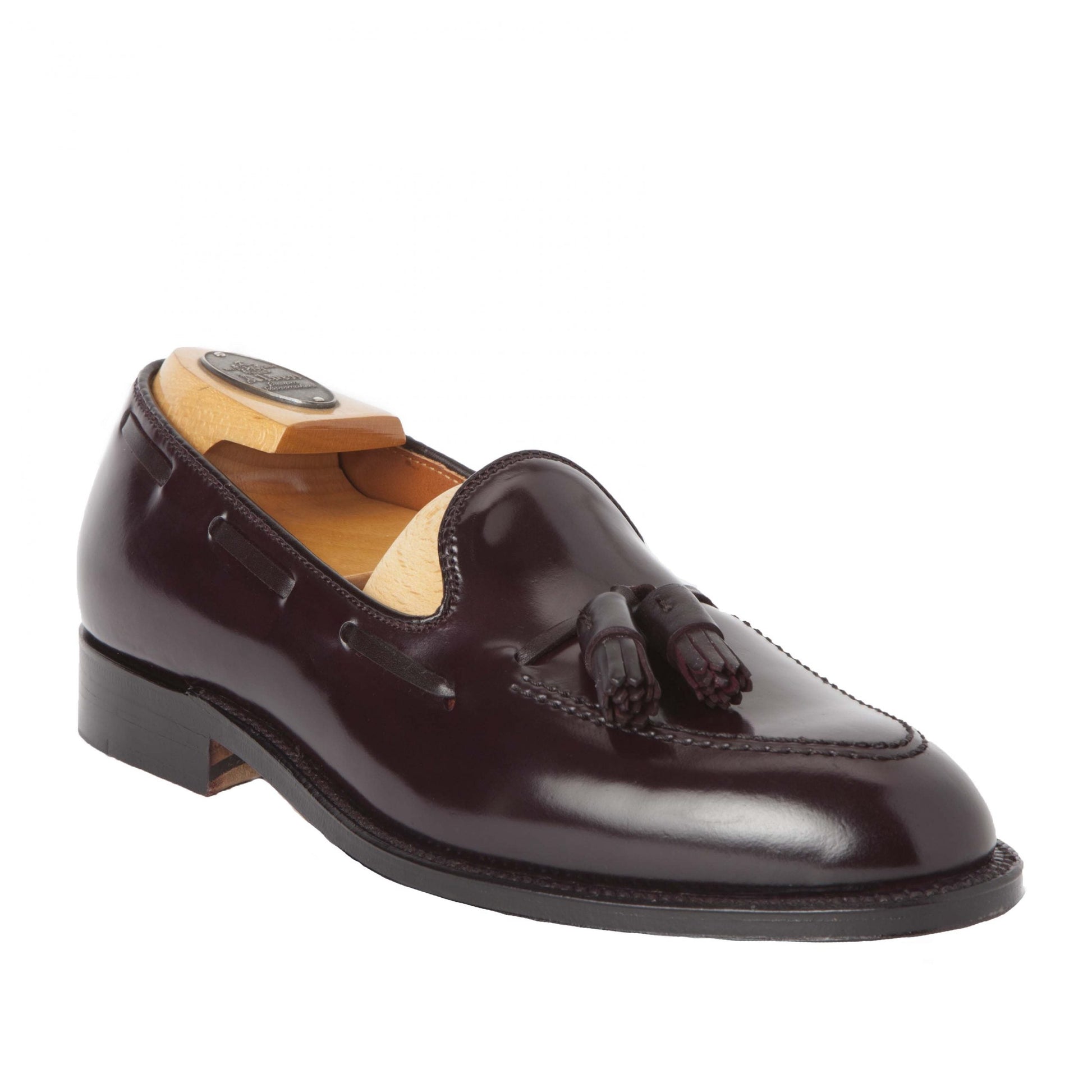 The Alden Madison 563 Tassel Loafer, in luxurious Color 8 Shell Cordovan, features a tassel design and elegant leather outsole. Displayed on a white background with a wooden shoe tree inside, it exemplifies polished sophistication.