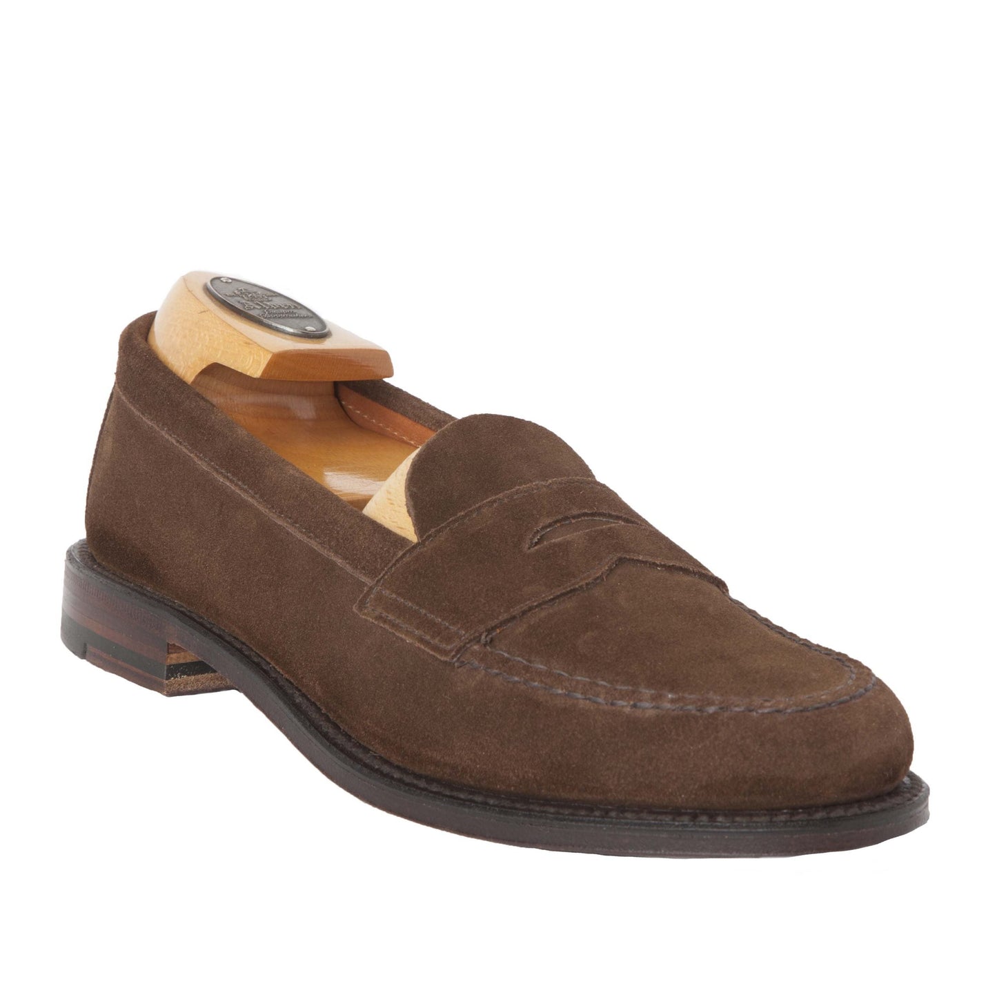 The Alden Madison Unlined Leisure Hand Sewn loafers in Brown Suede, with a wooden shoe tree inserted, showcase hand stitching and a timeless design. The flex leather sole features a subtle two-tone near the heel, while the rounded-handle shoe tree preserves their elegant shape.