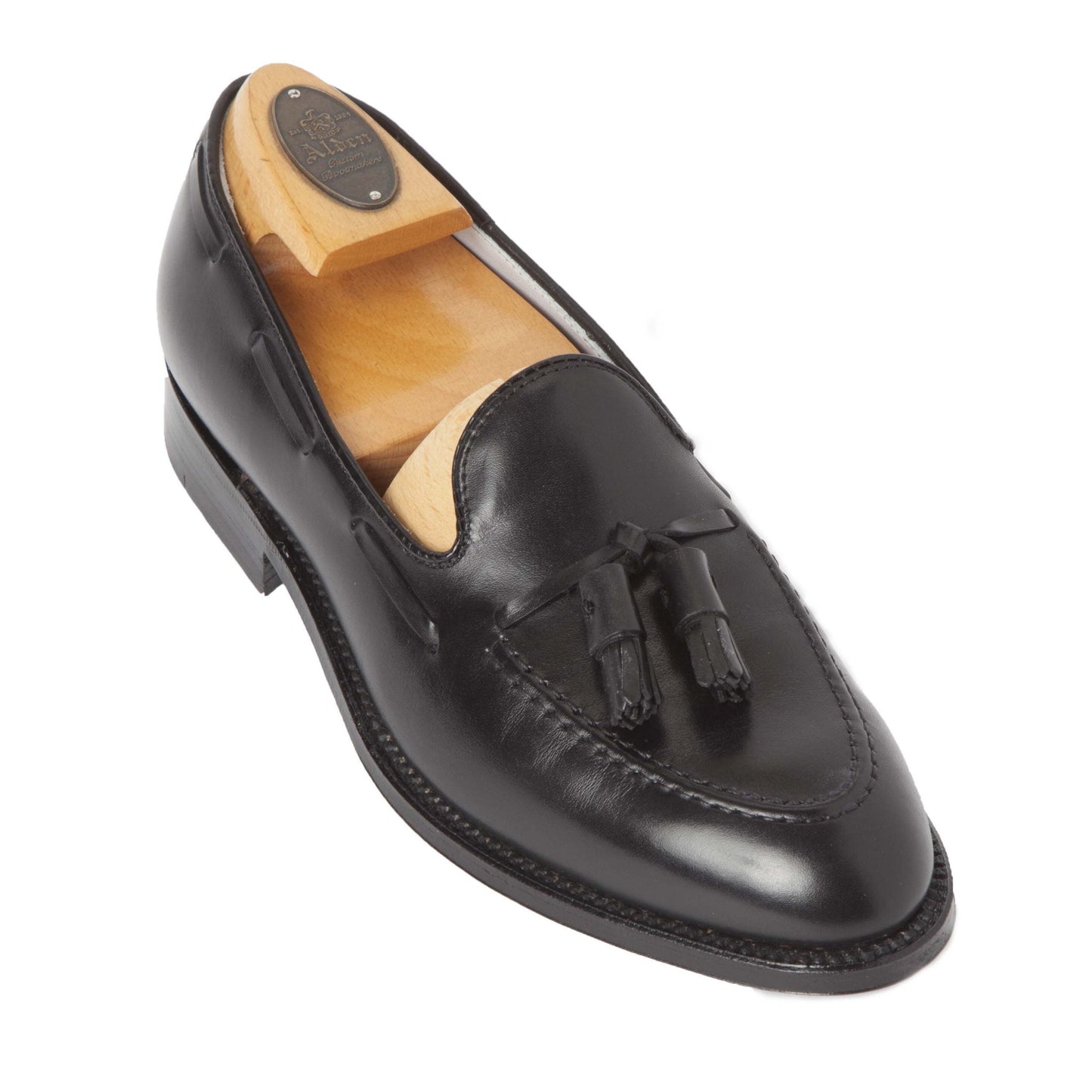 The Alden Madison 660 - Tassel Loafer in Black Calfskin, with its polished finish and classic design on the Aberdeen Last, is displayed with a wooden shoe tree on a white background.