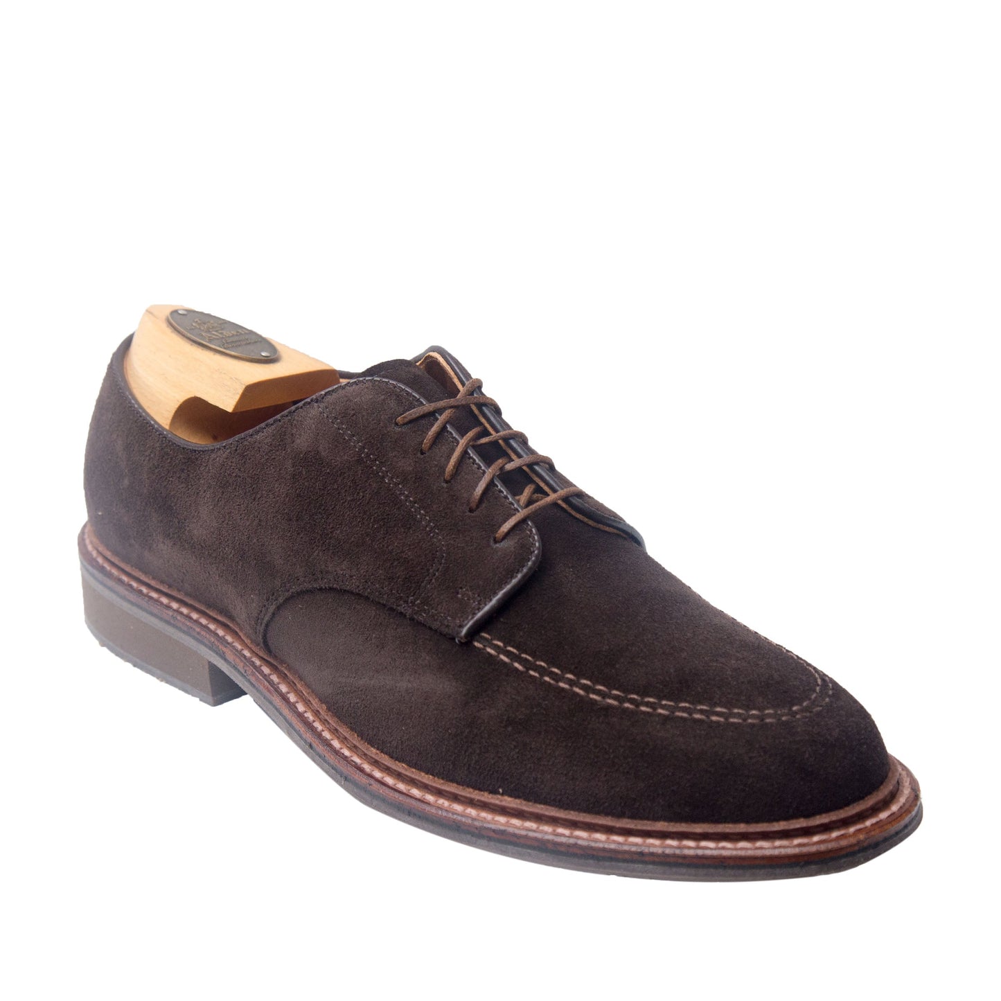 The Alden Madison 704 Mocc Toe Blucher in brown suede features brown laces, visible stitching, a dress rubber sole, and a wooden shoe tree on the classic Orleans Last, all displayed against a white background.