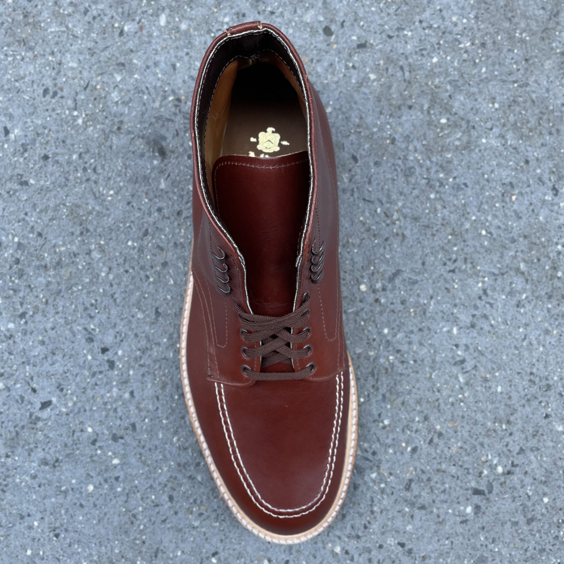 A single Alden Madison 405C - Original 405 Indy Boot with detailed stitching and decorative insole emblem is displayed on a textured gray surface, featuring a rugged Commando Sole.