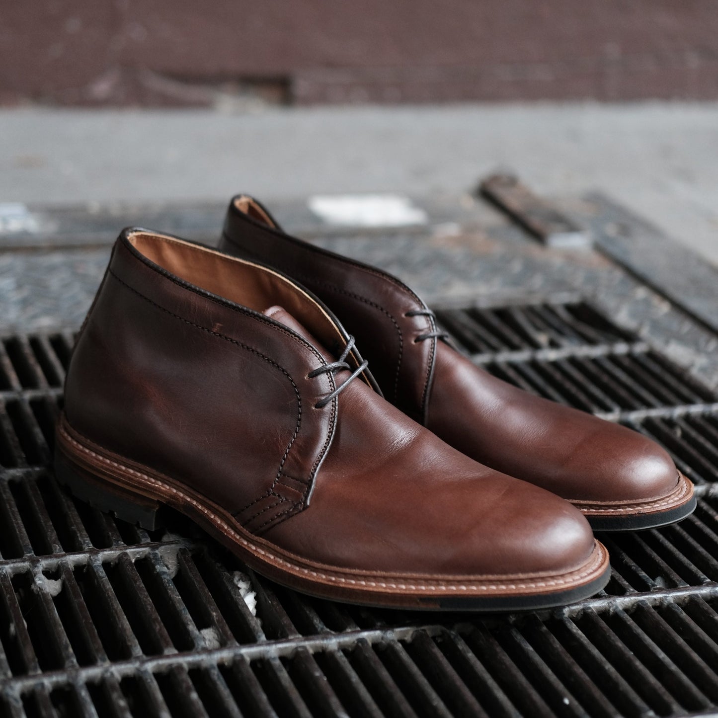 Alden Madison 13781C Chukka Boot in Brown Chromexcel with black laces, classic Barrie Last, and durable Commando Sole, shown on a metal grate with a blurred background—combining all-day comfort and timeless style.