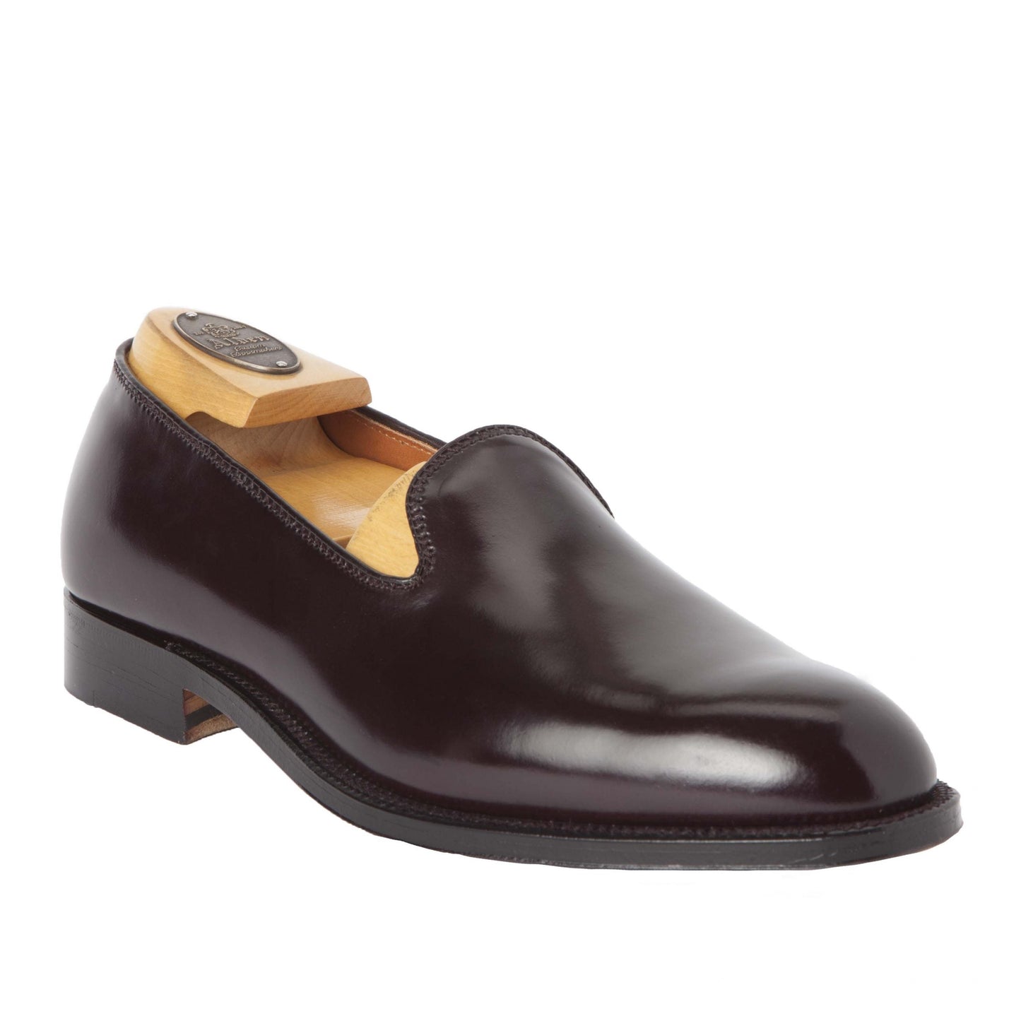 The Alden Madison 8818 - Plain Toe Slip On in Color 8 Shell is a polished, dark brown leather shoe. It features a sleek slip-on design with a low heel, crafted on the Aberdeen Last. A leather sole ensures durability and an included shoe tree maintains its shape.