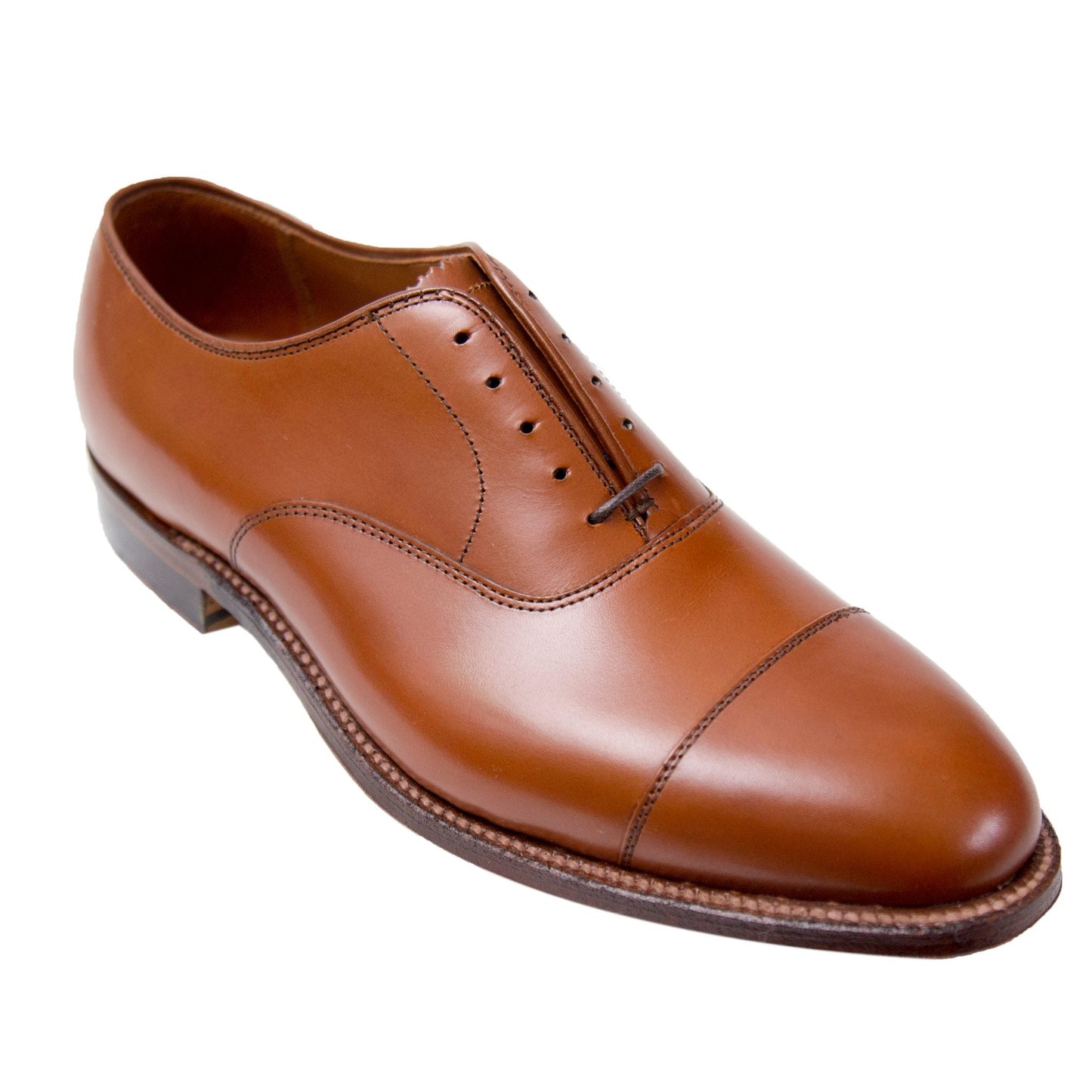 The Alden Madison 9062 is a brown leather oxford shoe in burnished tan calfskin, featuring a polished cap toe, detailed stitching, closed lacing, and resting on a dark single oak leather sole.