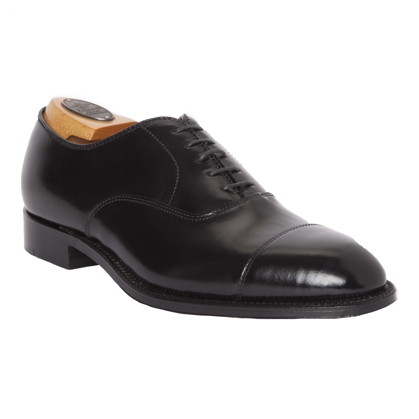 The 9071 - Straight Tip Bal in Black Shell Cordovan by Alden Madison features a polished black leather oxford style with cap toe, distinguished Hampton Last, single oak leather sole, black laces, and a wooden shoe tree—a classic elegance on a white background.