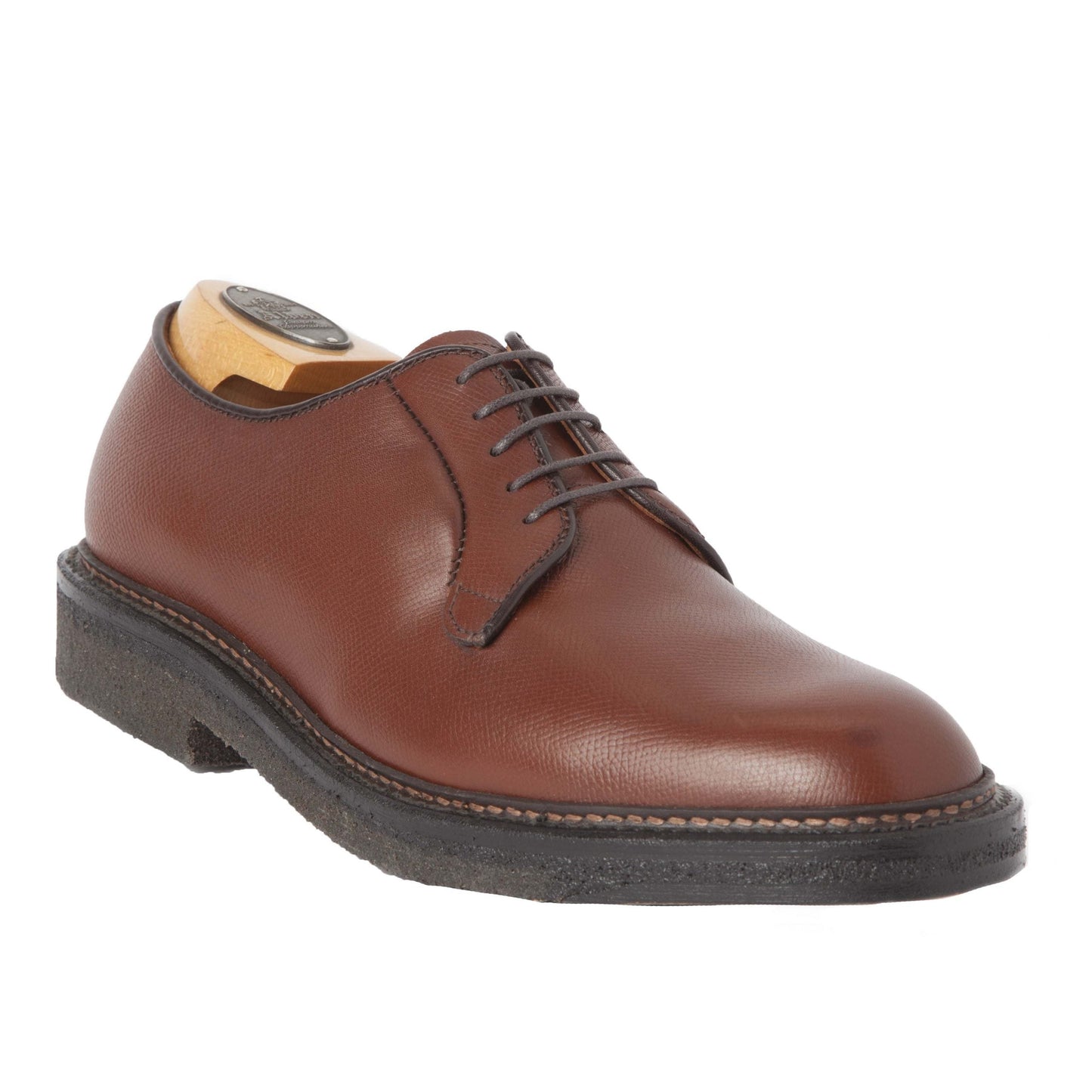 The Alden Madison 947 - All Weather Walker, a brown alpine grain calfskin leather derby with visible stitching and crepe sole on the Barrie Last, is elegantly fitted with a wooden shoe tree against a white backdrop, highlighting its timeless design.