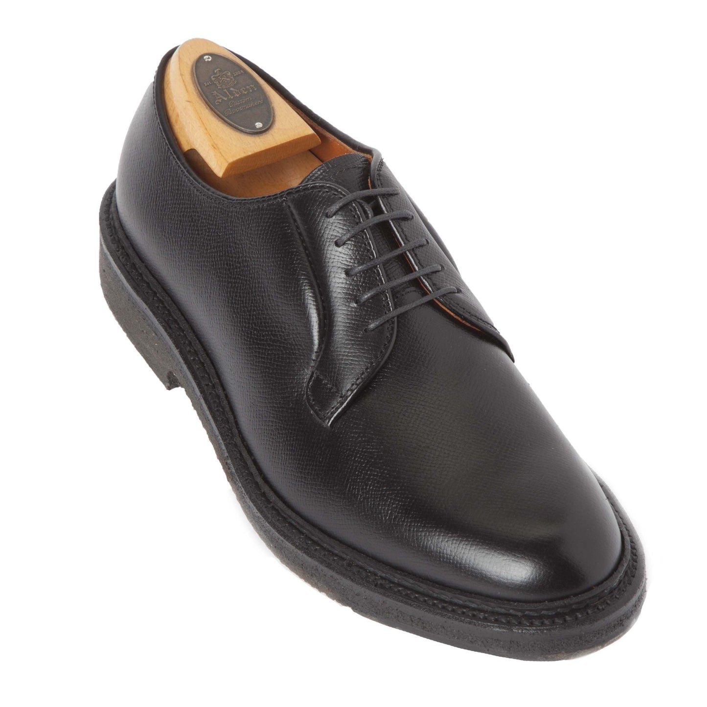 The Alden Madison 949 - All Weather Walker in Black Alpine Grain features a single black textured calfskin leather dress shoe with black sole and laces, and includes a wooden shoe tree with brass plate inside.