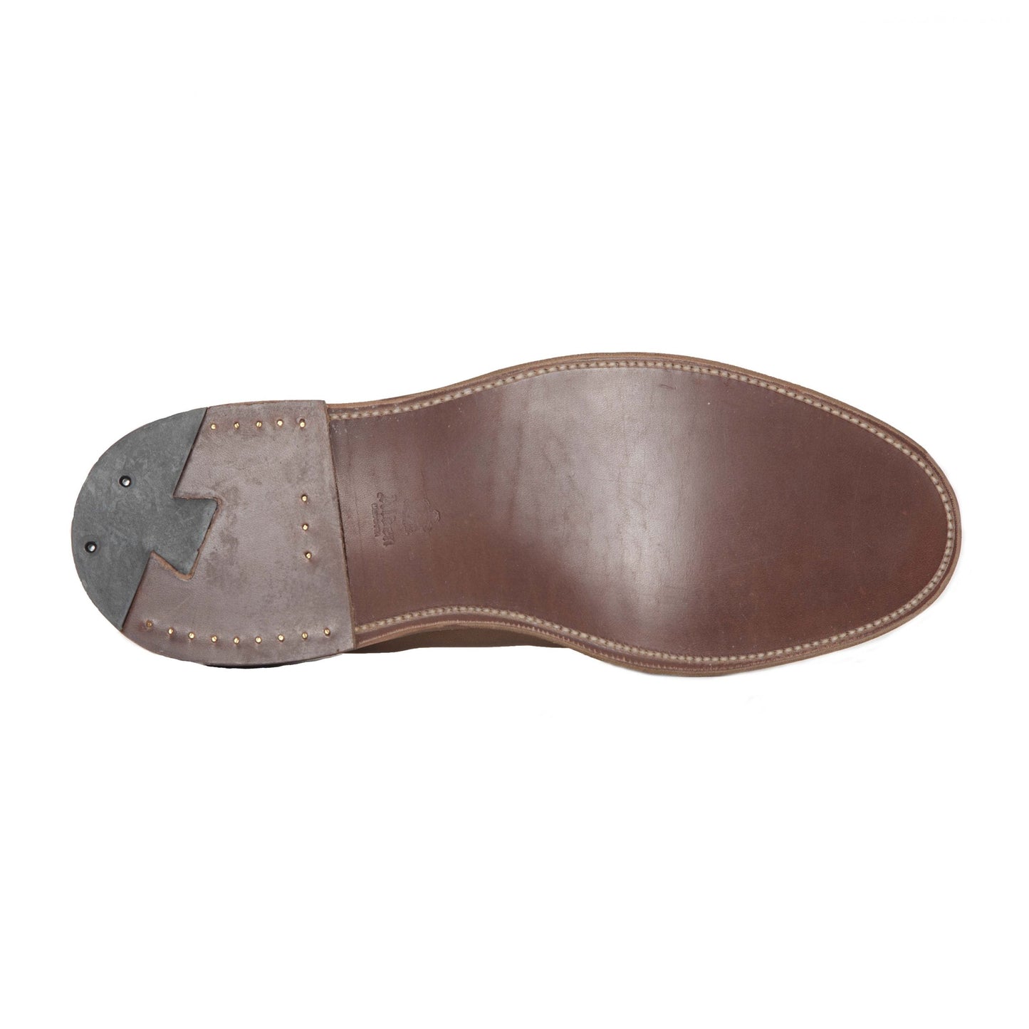 The image features the sole of Alden Madisons 1493 - Unlined Chukka in Snuff Suede, showcasing a stitched border, single flex leather sole, gray textured heel with two black rubber pads, and copper-colored nails.