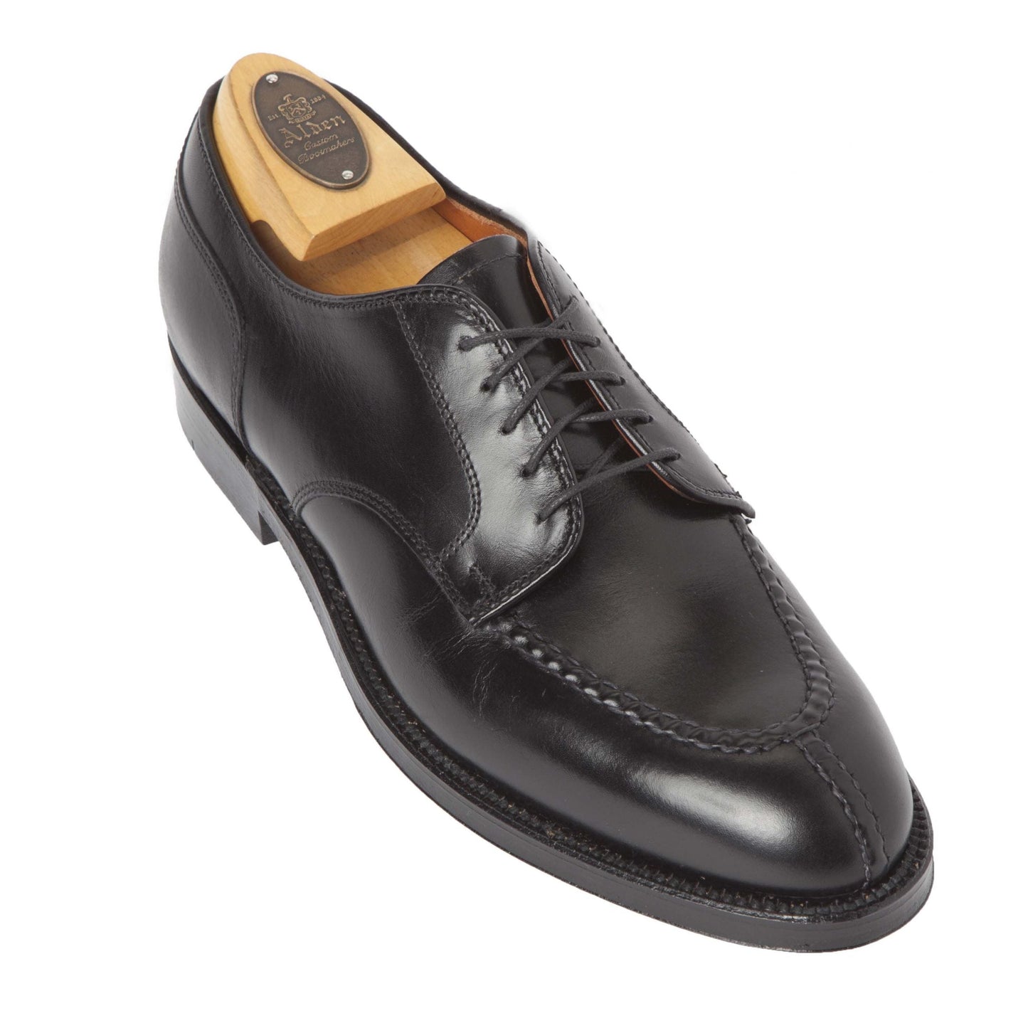 The Alden Madison 961 - Norwegian Split Toe Blucher is a black calfskin dress shoe with a polished finish and lace-up closure. It features the Aberdeen last, decorative side and front stitching, and includes a wooden shoe tree.