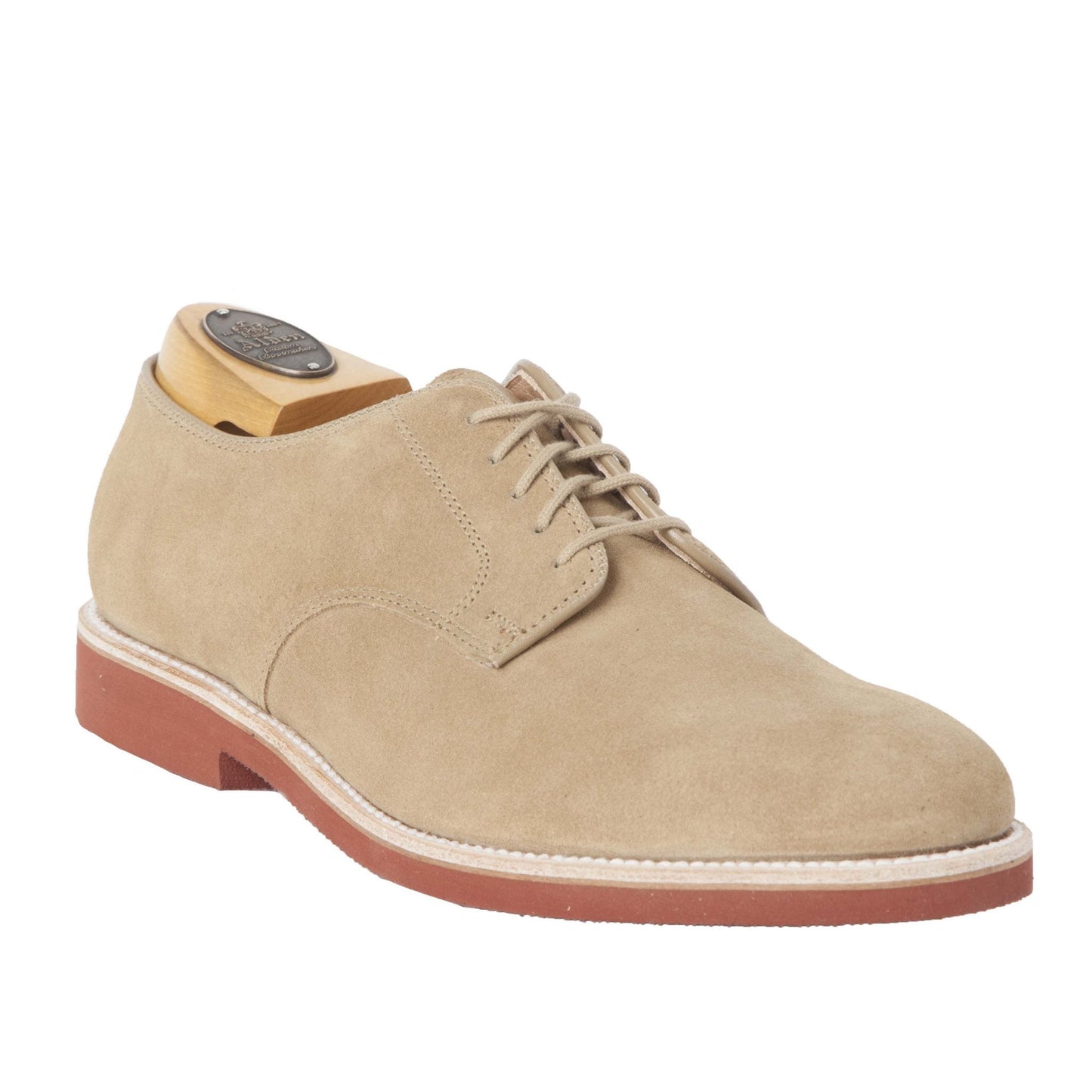 Viewed from a slight angle, the 96803 - Dirty Buck in Tan Suede by Alden Madison features a red rubber sole, white stitching, and comes with a wooden shoe tree insert. This lightweight design ensures style and comfort for any occasion.