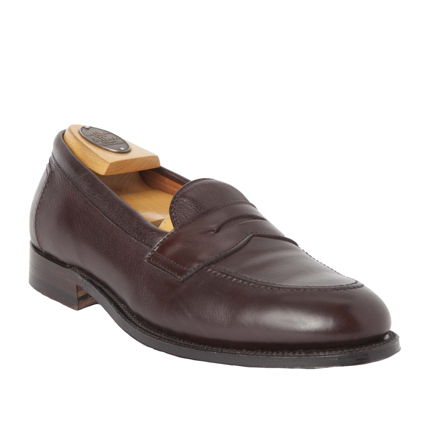 The 9694F - Flex Penny Loafer by Alden Madison is crafted in polished brown Lady Calf leather with a classic penny slot on the sleek Copley Last. It features a wooden shoe tree, leather sole, low heel, and slightly pointed toe for an effortlessly refined look.
