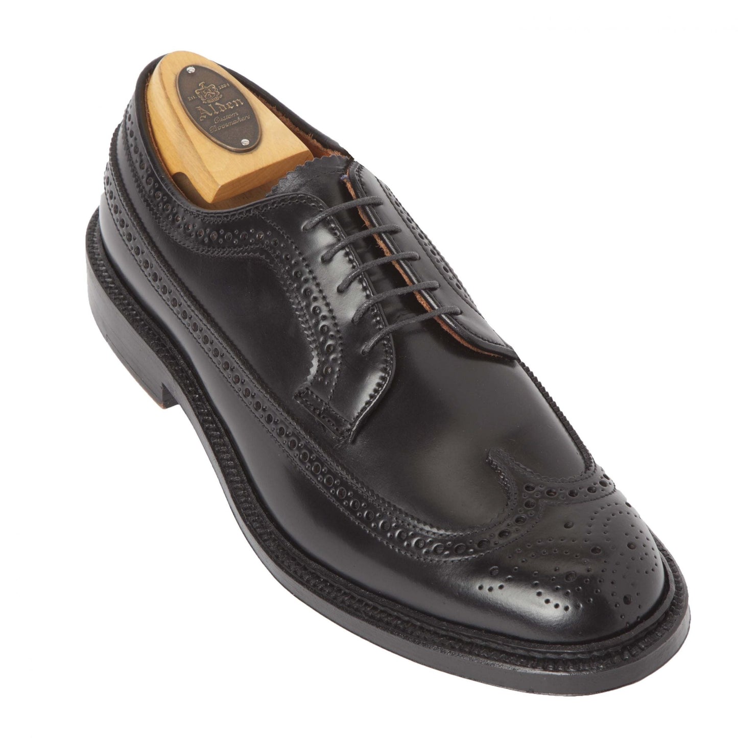 The Alden Madison 9751 - Long Wing Blucher in Black Shell Cordovan features a classic wingtip design with a Double Oak Leather Sole and includes a wooden shoe tree. Intricate perforations and detailed stitching enhance its elegance, resting on a white background.