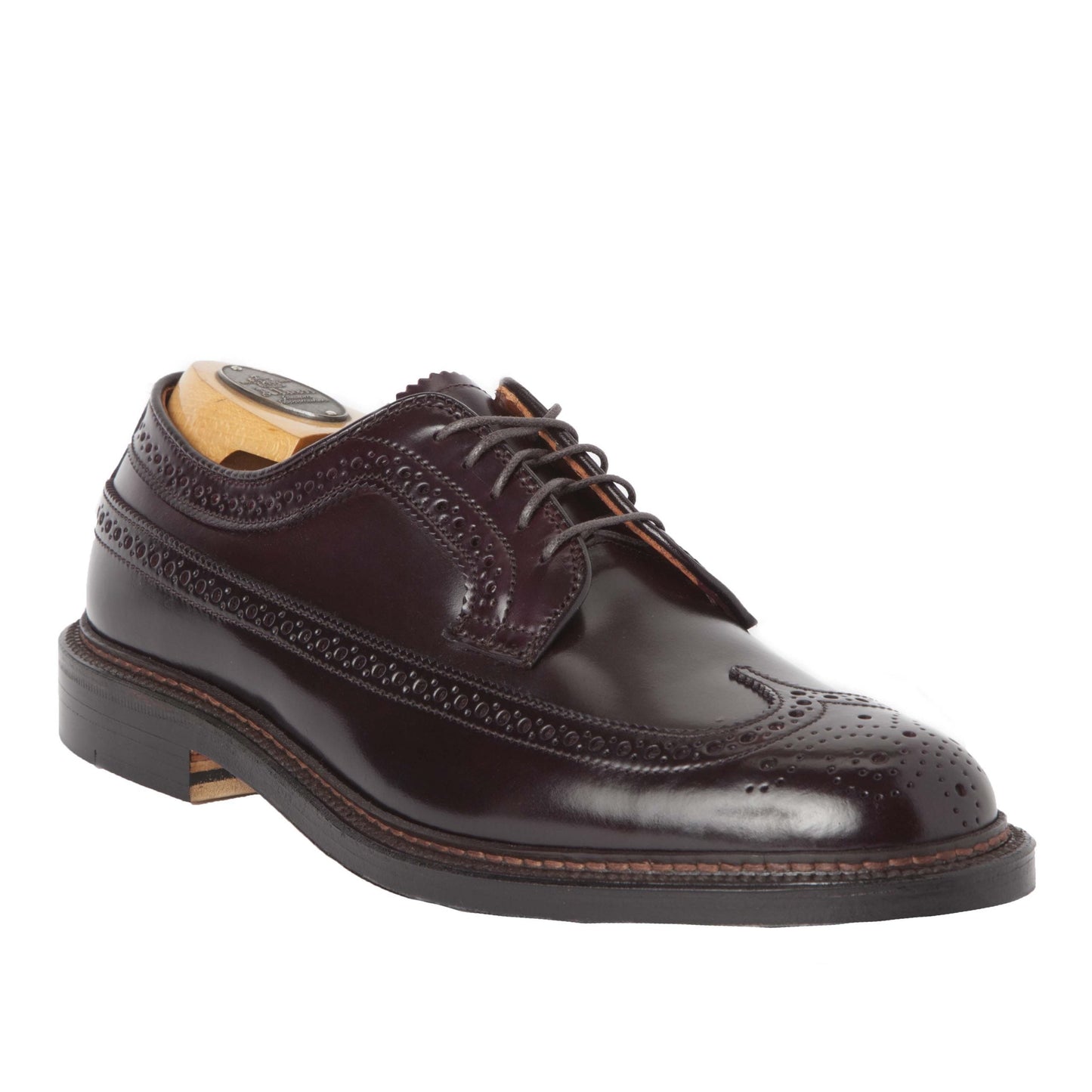 The Alden Madison 975 Long Wing Blucher in Color 8 Shell Cordovan features an intricate design with a polished finish. Crafted on the Barrie Last with a Double Oak Leather Sole, it includes a wooden shoe tree for an elegant display.