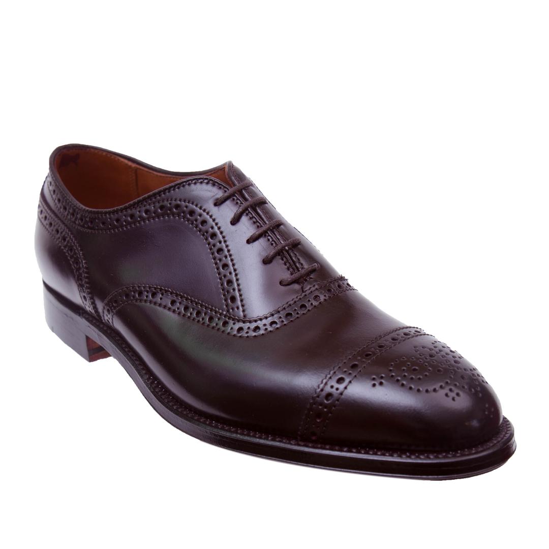 The Alden Madison 9854 Medallion Cap Toe Bal in Color 8 Shell Cordovan is a dark brown leather dress shoe with brogue detailing, featuring a lace-up design on a Hampton Last. It has decorative perforations for timeless elegance and a polished finish.