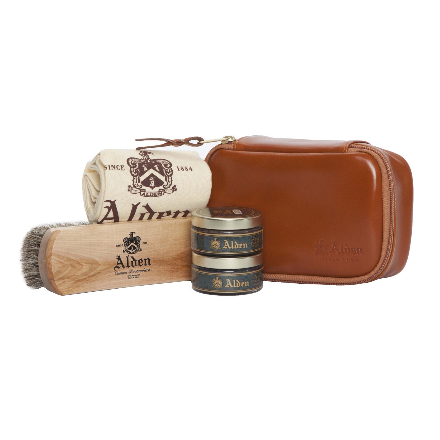 The Alden Madison Polish Kit includes a Calfskin Carry Case with a zippered pouch, an Alden-branded cloth, a Horse Hair Brush, and two tins of Alden Paste Wax polish, all elegantly designed for refined shoe maintenance.