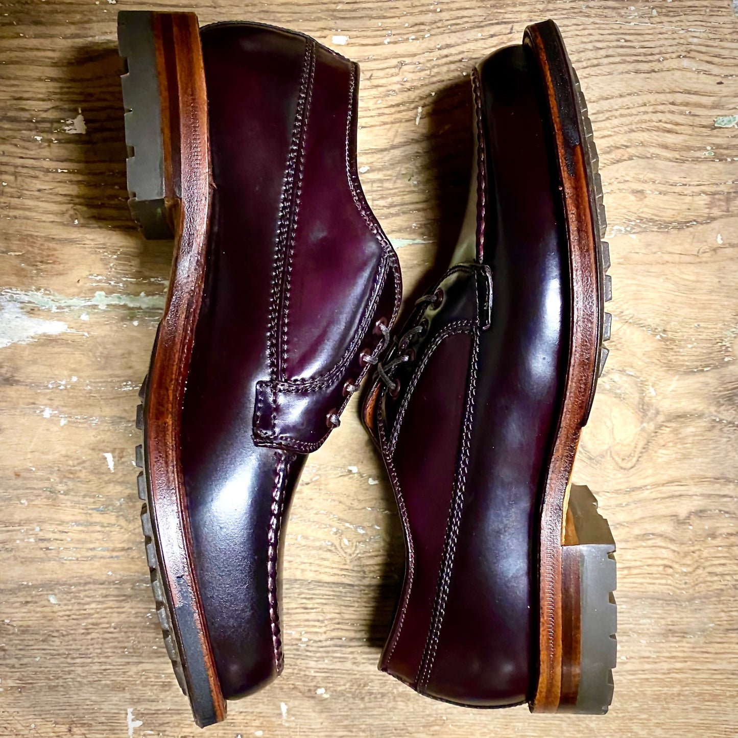 A pair of Alden Madison D9613C - Ranger Mocc in Color 8 Shell Cordovan with dark laces and thick Commando Soles, placed side by side on a wooden floor.