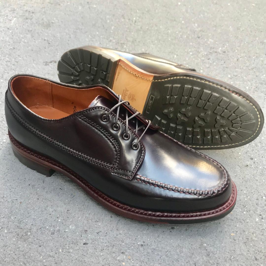 Alden Madison’s D9613C - Ranger Mocc in Color 8 Shell Cordovan: a pair of dark burgundy leather dress shoes with commando soles and black laces—one upright, the other on its side to show the rugged tread—displayed on a gray surface.