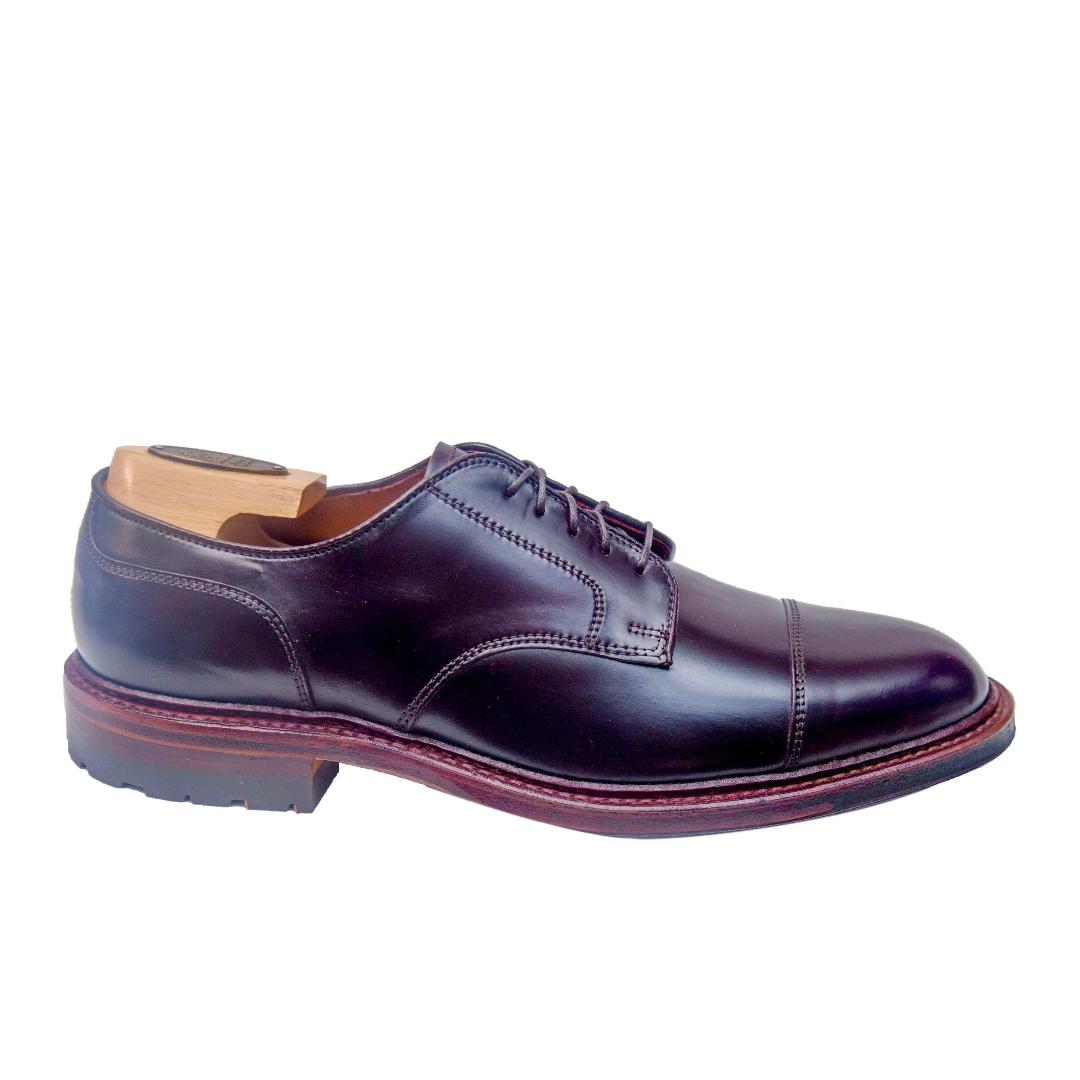 The Alden Madison D8516C - DeRosa Captoe Blucher in Color 8 Shell is a polished dark brown leather shoe crafted on the Barrie Last, with a cap toe and antique edge. It features a red-brown welted sole, complemented by a wooden shoe tree against a plain white background.