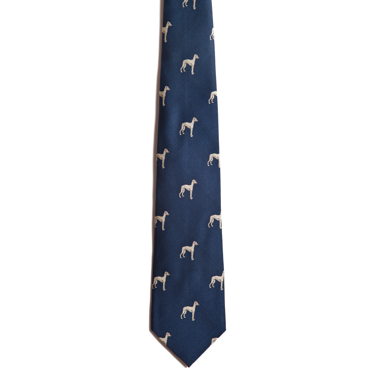 The Alden Madison Greyhound is a navy blue silk necktie featuring a repeating pattern of small, light-colored greyhound silhouettes, shown on a white background—ideal for those wanting a stylish dog breed accessory.