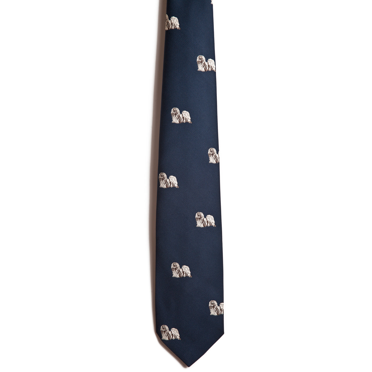 The Alden Madison Lhasa Apso silk necktie is a deep navy with a playful pattern of embroidered Lhasa Apso dogs evenly spread across the fabric, enhanced by sophisticated jacquarding.