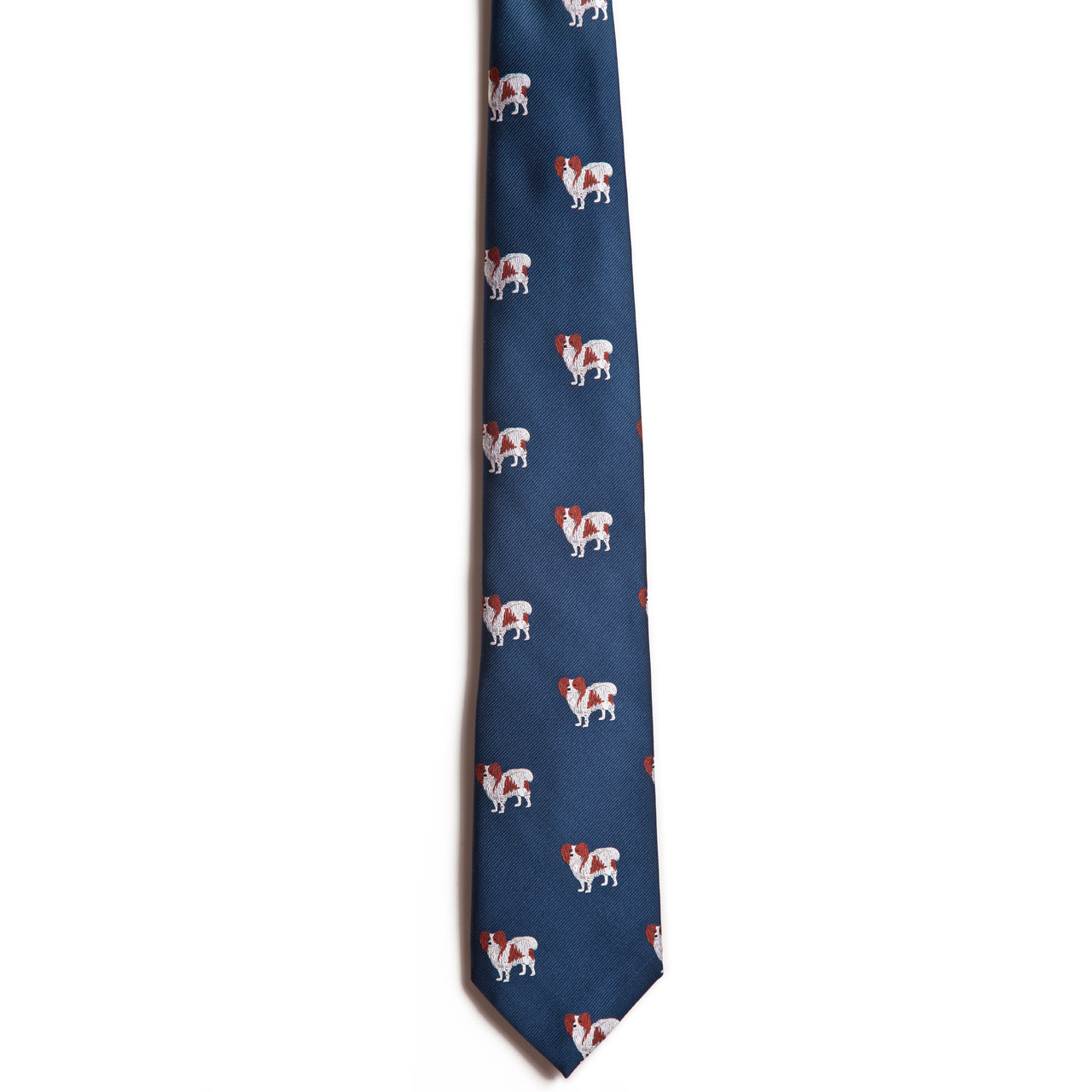 The Papillon necktie by Alden Madison is a navy blue silk jacquard tie with a repeating pattern of small white and brown dog illustrations.