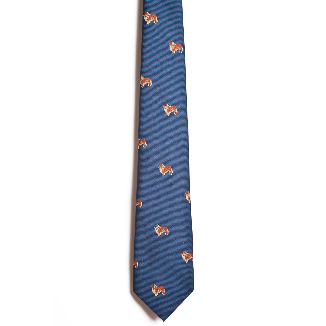 Alden Madisons Shetland Sheepdog necktie is a blue silk jacquard tie with a repeating pattern of small, embroidered Shetland Sheepdogs on a white background—ideal for any dog breed necktie enthusiast.