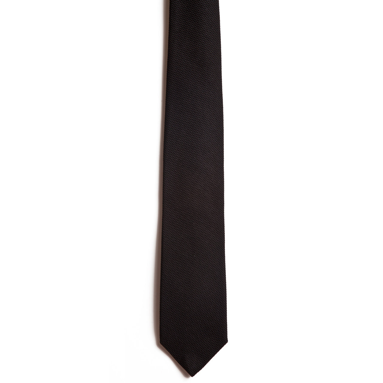 On a white background, heres a close-up of Alden Madisons Black necktie. Fashioned from luxurious Italian silk, it embodies expert craftsmanship with its subtle textured pattern and classic pointed tip.