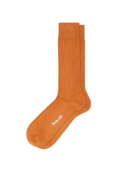 A pair of orange Danvers mid calf rib knit men's dress socks from ALDEN SHOES, with the brand name written in white on the sole, laid flat on a white background.