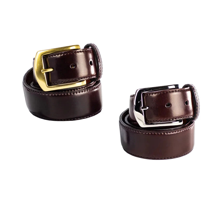 Two Alden Madison 38mm Color 8 Shell Cordovan belts are shown—one with a nickel buckle, one with a brass buckle—both neatly coiled on a white surface.