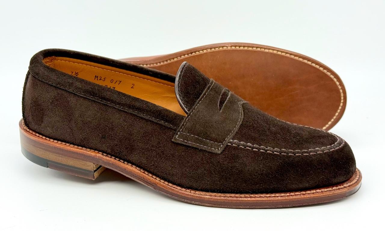 The Alden Madison 6176F Penny Loafer in Dark Chocolate Suede, featuring a Flex Oiled Leather Sole and wooden heel, is shown on a white background—one shoe upright, the other on its side to highlight the sole detail.