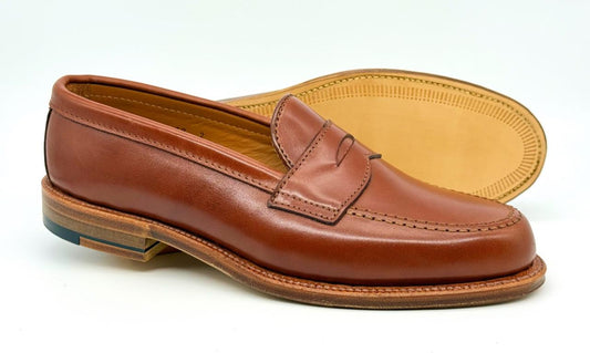 The Alden Madison 9823 - Penny Loafer in Tan Michigan Calf, featuring a penny slot detail, stitched seams, and a Flex Oiled Leather Sole, is shown against a plain white background.