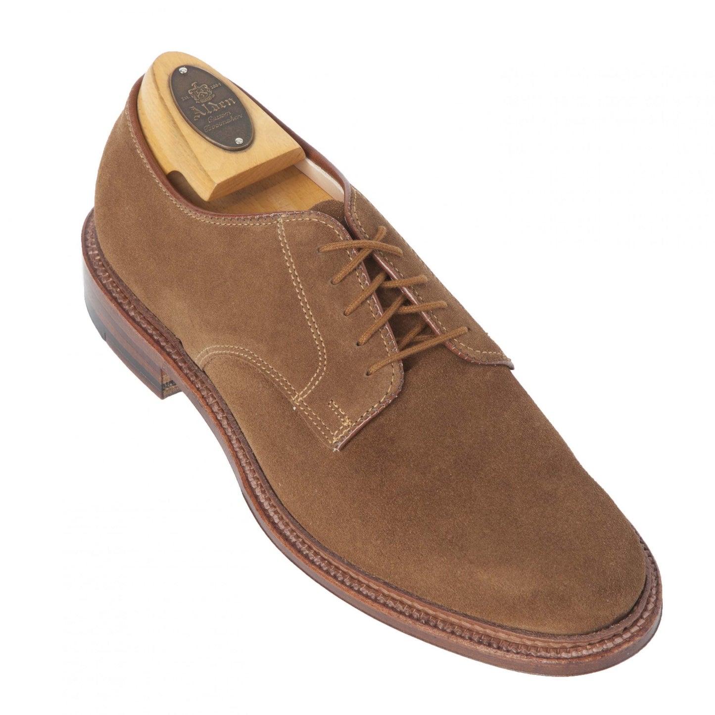 The Alden Madison 29336F - Unlined Plain Toe Blucher in snuff suede features visible stitching and a leather sole. Designed on the Barrie last, it includes a wooden shoe tree, low heel, and smooth finish, showcased against a white background.