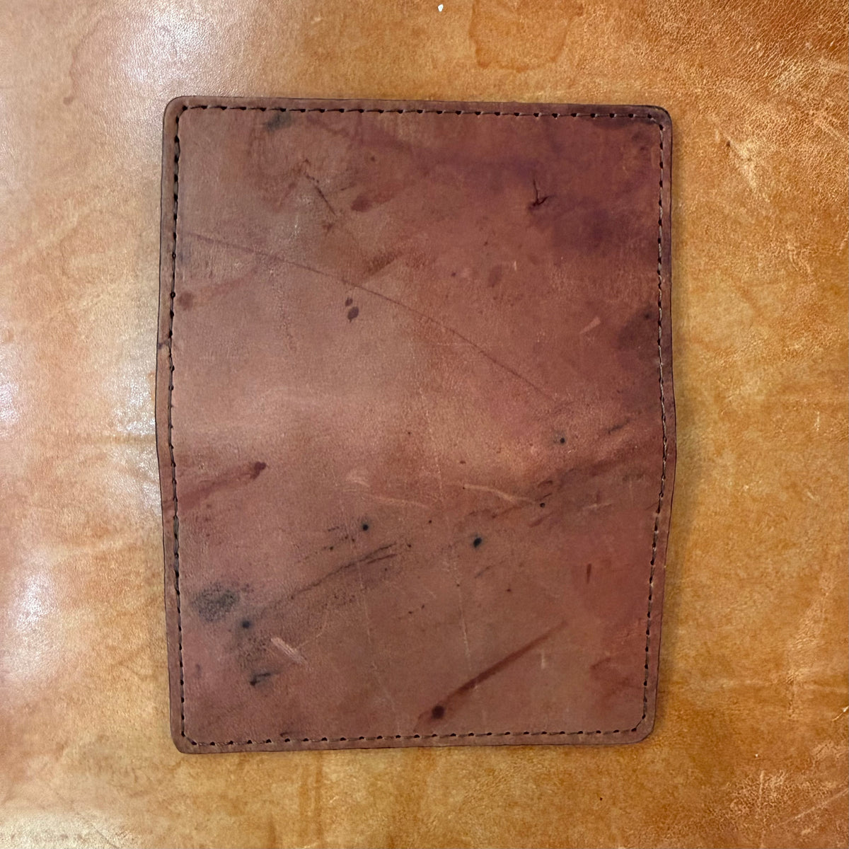 A slim, reddish-brown Credit Card Wallet in Shell Cordovan with visible stitching along the edges and four card slots.