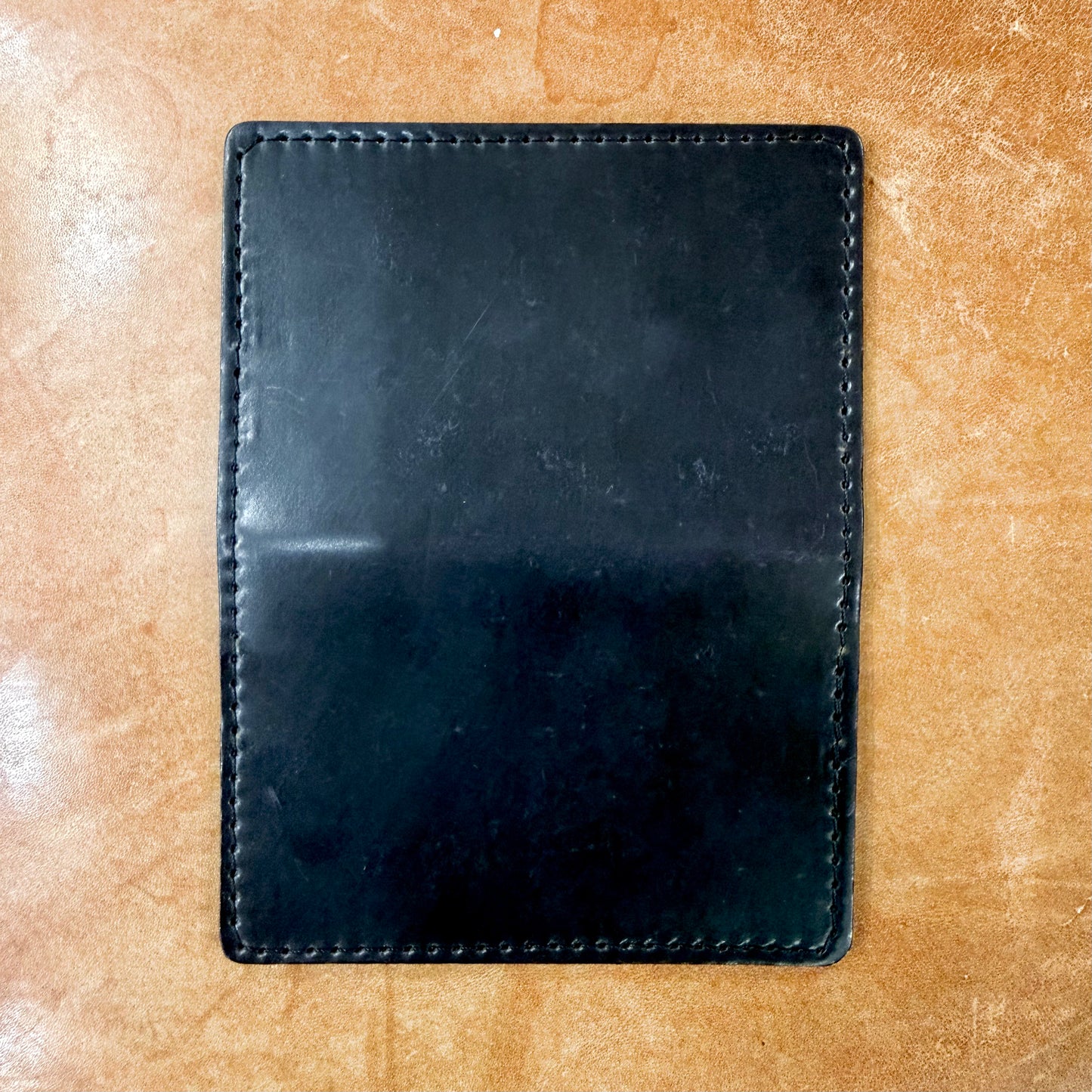 A rectangular black Credit Card Wallet in Shell Cordovan by Alden Madison with perimeter stitching and four card slots.