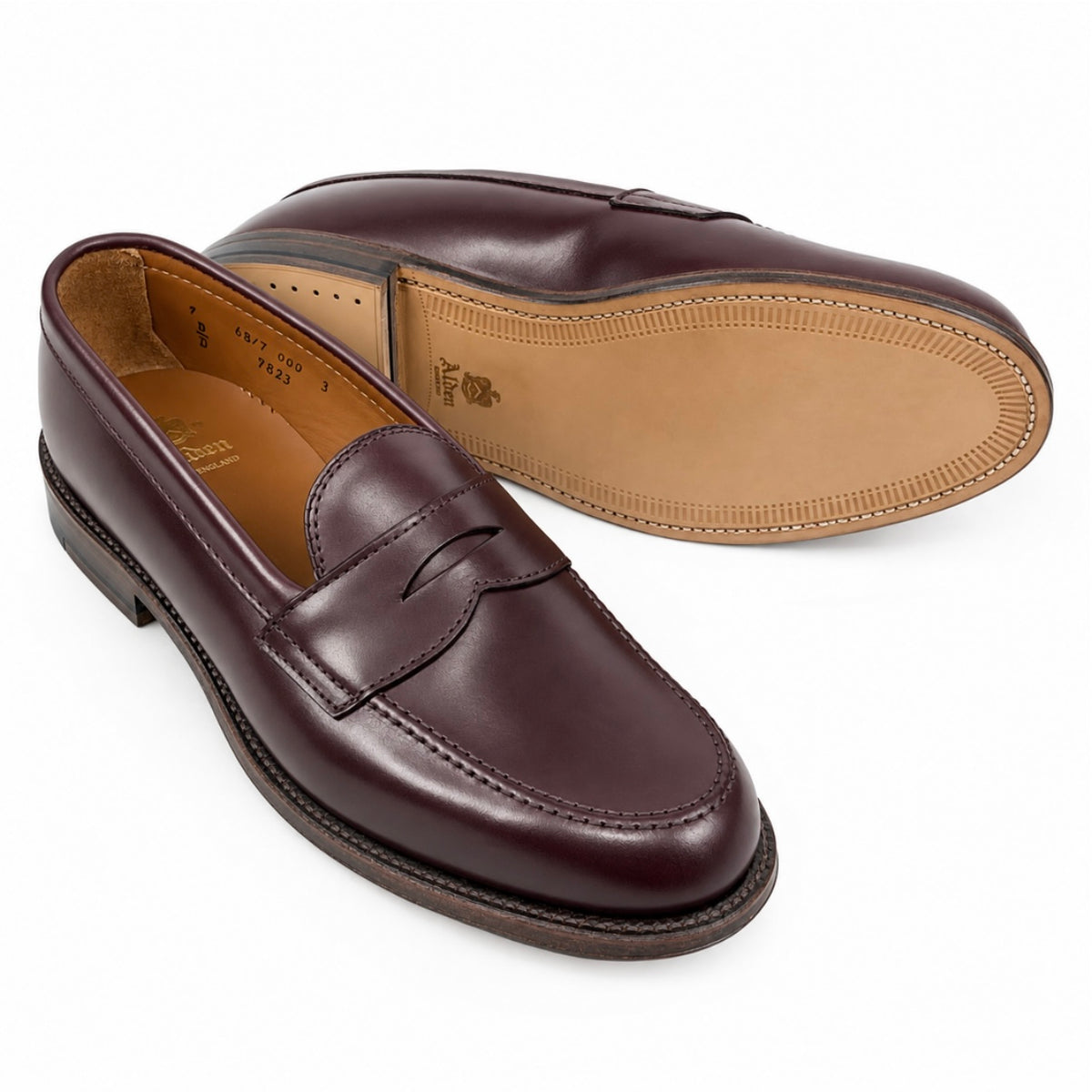 A side view of the 9836 - Leisue Penny in Burgundy Calfskin, with a second loafer positioned behind it displaying the smooth leather outsole.