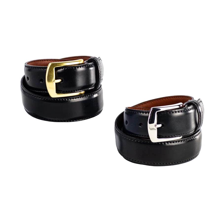 Two Alden Madison 32mm Black Shell Cordovan Belts—one with a brass buckle atop a white cube, the other with a nickel buckle on the surface—are neatly rolled. Both are proudly made in the USA.