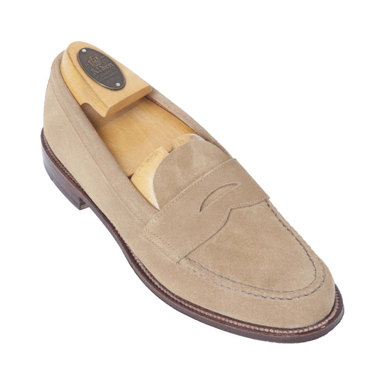 Alden Madisons 6244F - Unlined Leisure Hand Sewn in Tan Suede features a wooden shoe tree, hand-stitched seams, and a brown leather sole. Displayed on a white background, the loafers are angled left to highlight their expert craftsmanship.