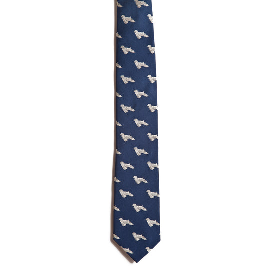 The Alden Madison Cocker Spaniel tie is dark blue silk with an elegant pattern of small, white embroidered Cocker Spaniels, set against a solid background to emphasize the jacquard detailing.